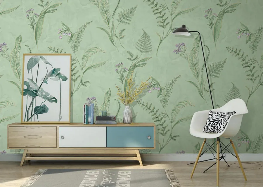 Calm reception corner with a sage botanical fern wallpaper and a white chair